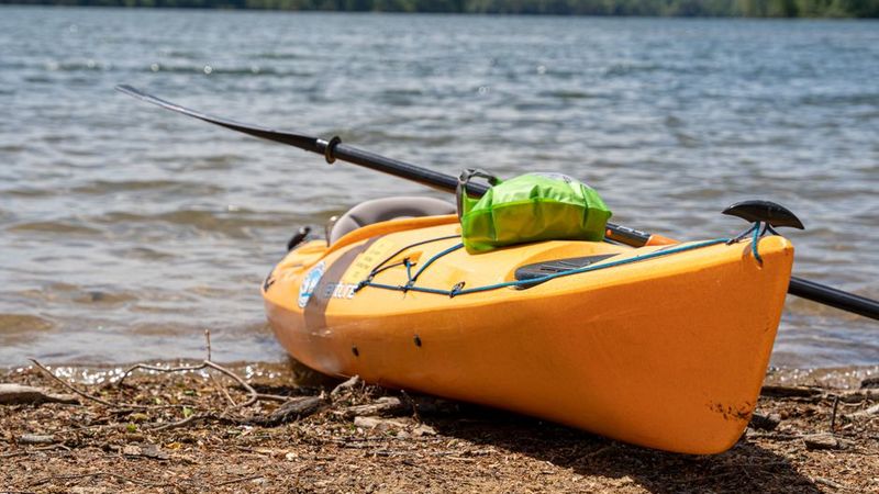 Dry bag strapped to a kayak deck at the shore
