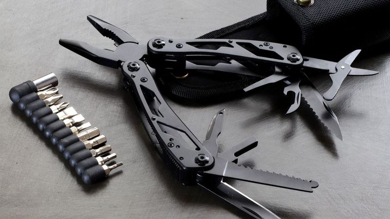 Black multi-tool opened on steel