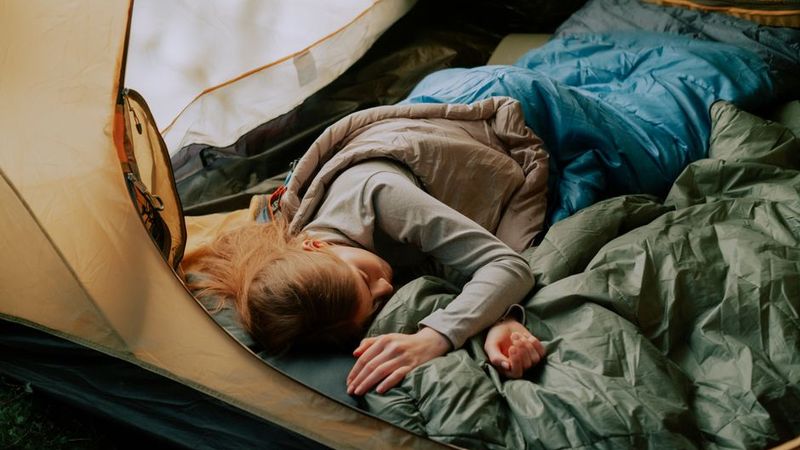 Sleeping in a warm bag inside a tent at sunrise