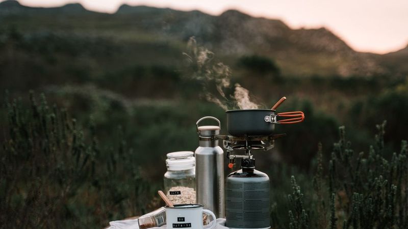 Steaming pot on a canister stove at dusk